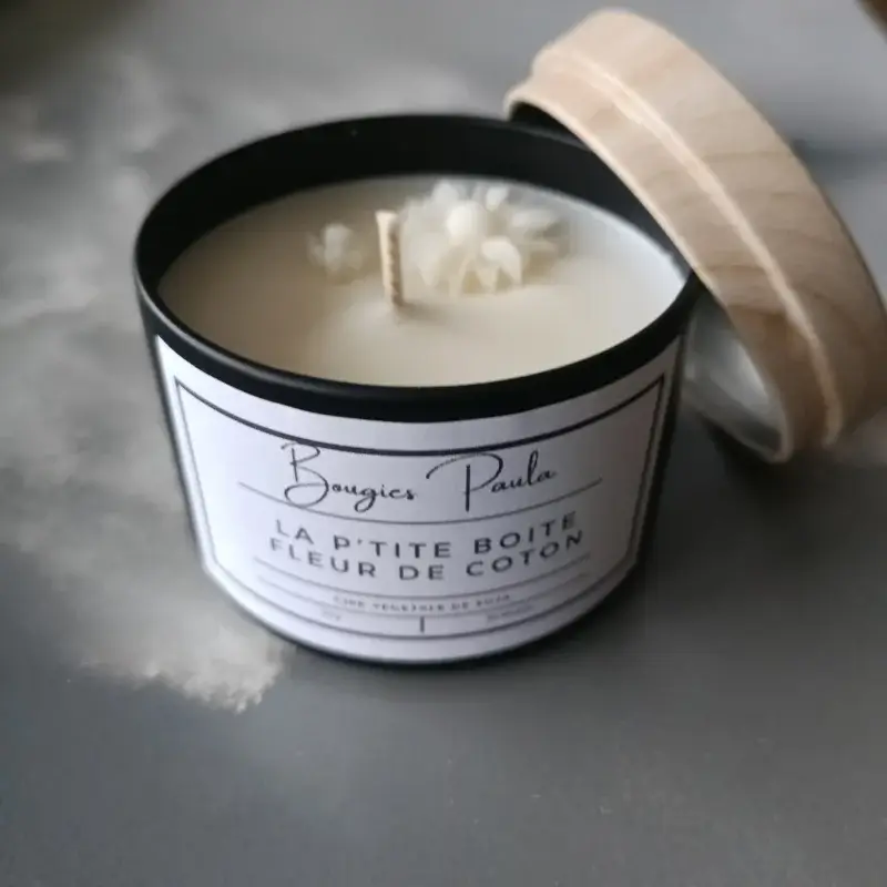 Bougie parfumée dans un pot en fer noir disposée sur un fond faisant apparaitre une vague pendant la tempête.