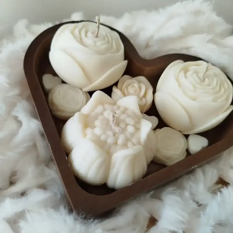 Coeur en bois accueillant des bougies blanches en formes de fleurs.