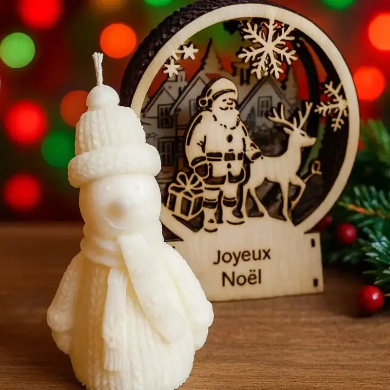 Bougie bonhomme de neige sur un fond de décor de Noël.