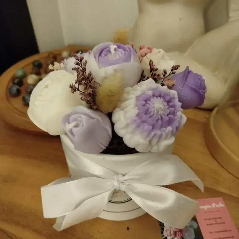 Bouquet de bougies parme et blanc avec un noeud blanc soyeux.