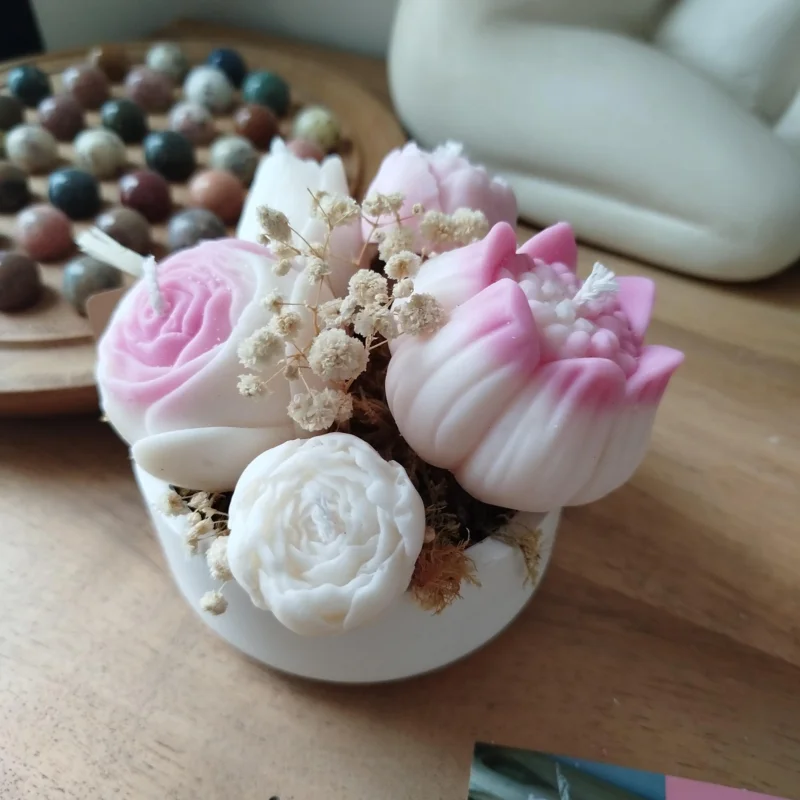 Composition florale en bougies dans une coupelle.